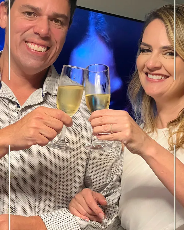 Os noivos brindando, com a moldura do casamento